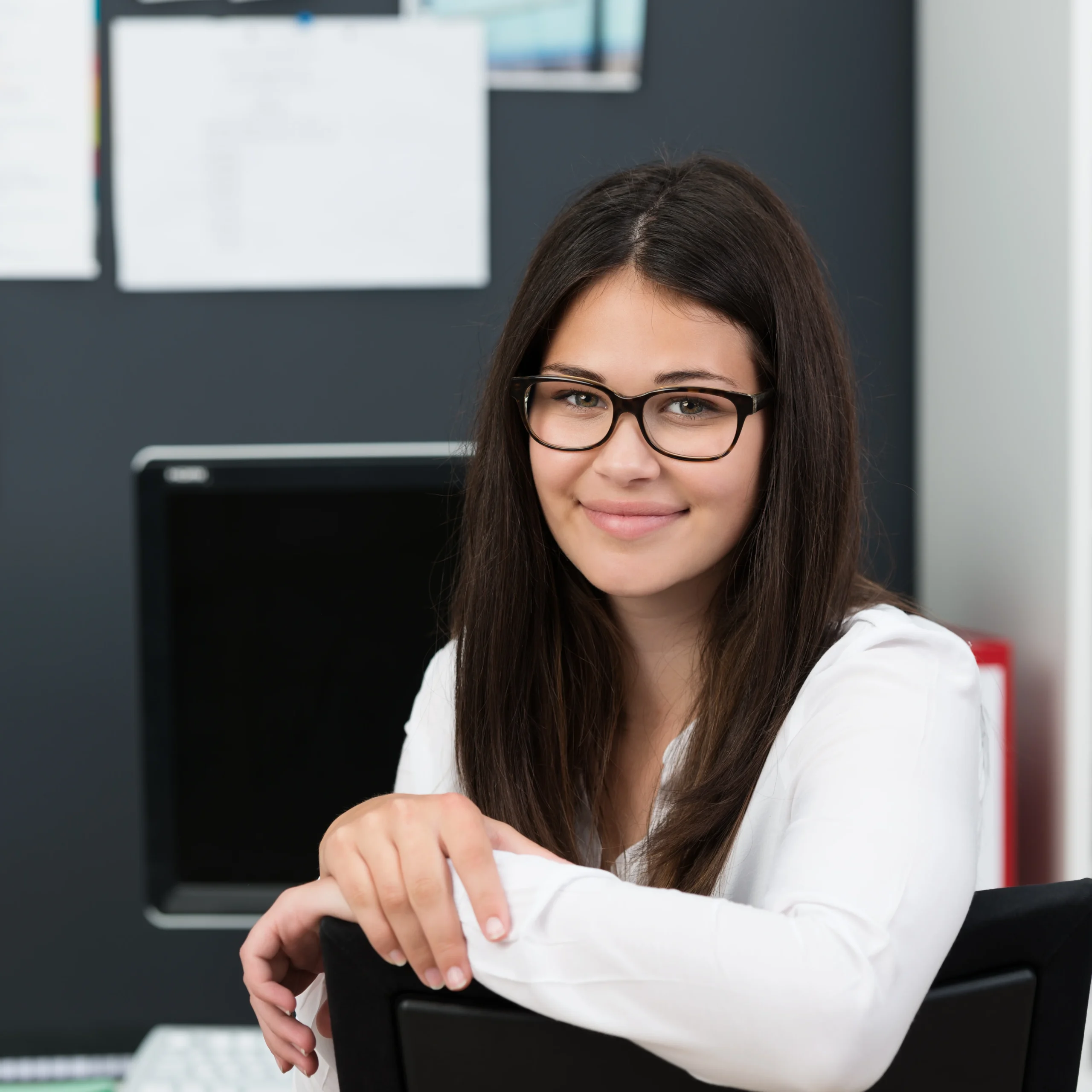 A friendly and professional lead growth specialist sitting at her workspace, focused on executing viral marketing campaigns to scale profiles within our onlyfans agency.