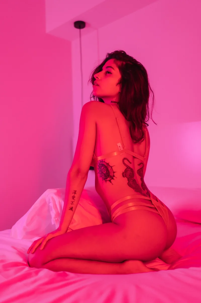 OnlyFans agency for trans creators Creator posing in pink light, representing confident personal branding and identity for trans OnlyFans growth.
