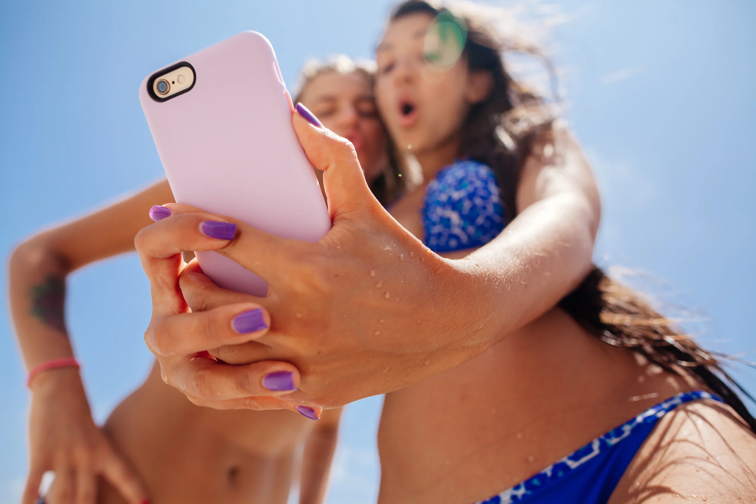 Two creators taking a selfie while learning how an OnlyFans agency helps with management, promotion, and account growth